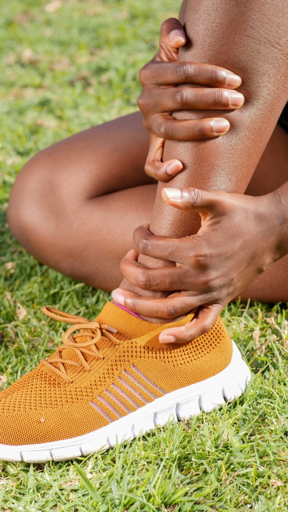 close up of woman holding an injured ankle